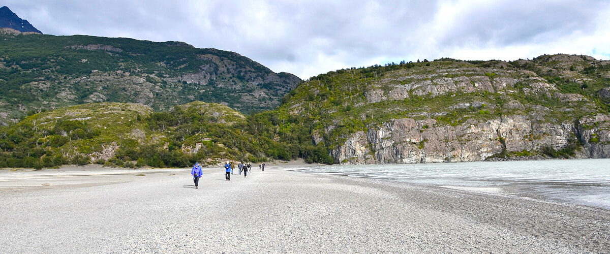Group Walking Alongside Grey Lake